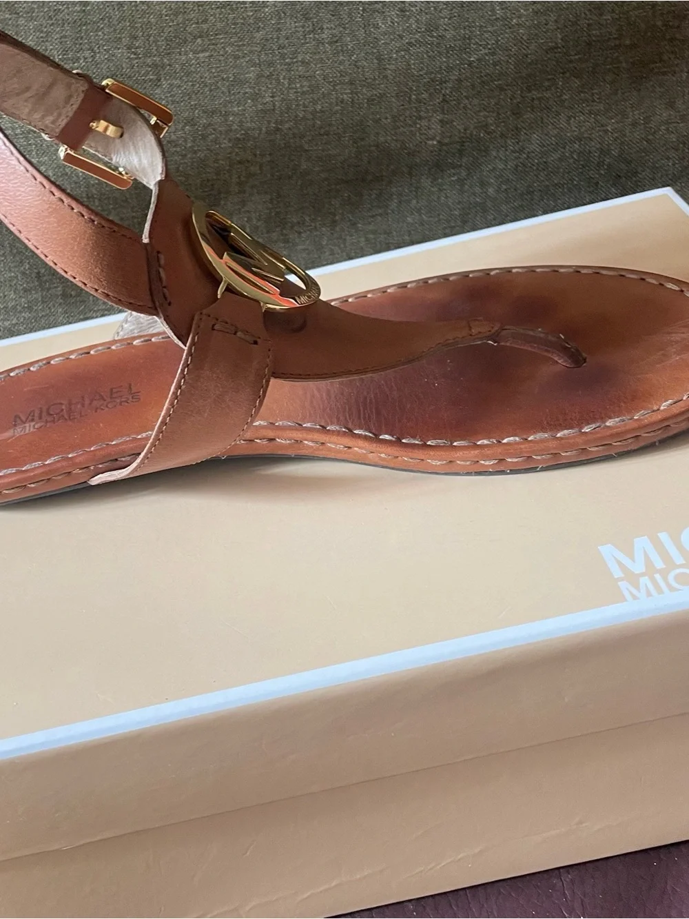 Michael Kors tan leather thong sandals feature a polished gold-tone MK log